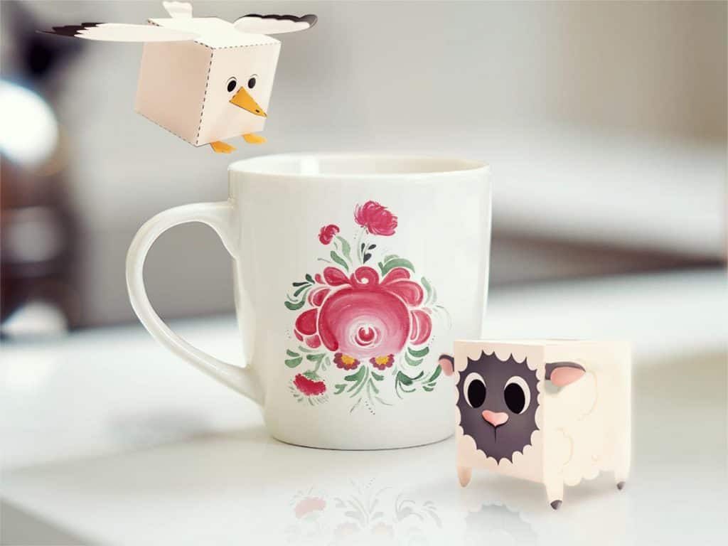 Pappfiguren eines Schaafs und einer Möwe, die an einem ostfriesischen Becher stehen.