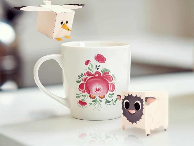 Pappfiguren eines Schaafs und einer Möwe, die an einem ostfriesischen Becher stehen.