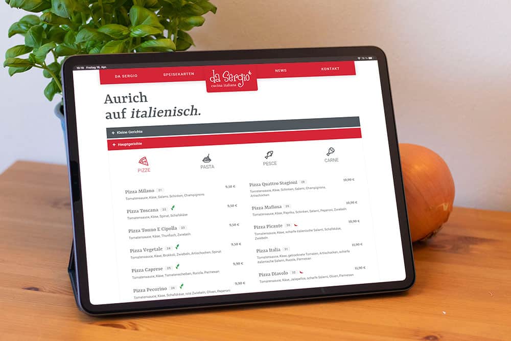 Man sieht ein Tablet auf dessen Bildschirm die Webseite von daSergio abgebildet ist.